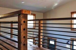 A wooden railing with metal bars on each side.